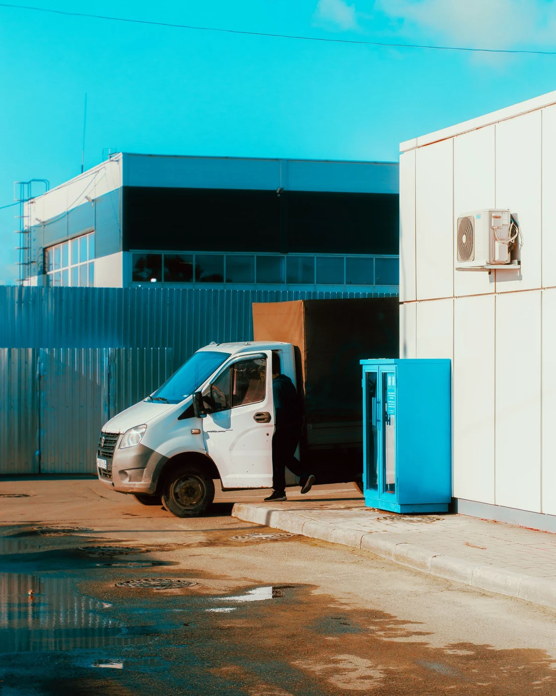 Un utilitaire de livraison blanc en zone industrielle
